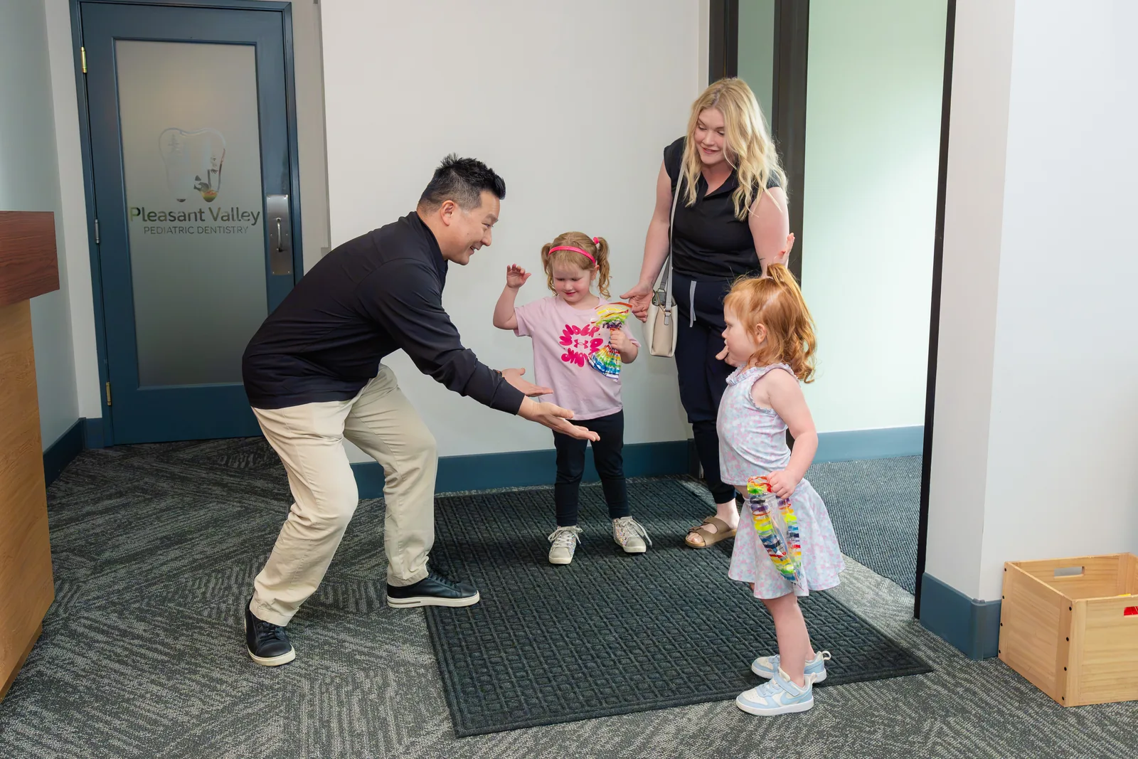 Dr. Kurt Truong greeting two young patients as they arrive
