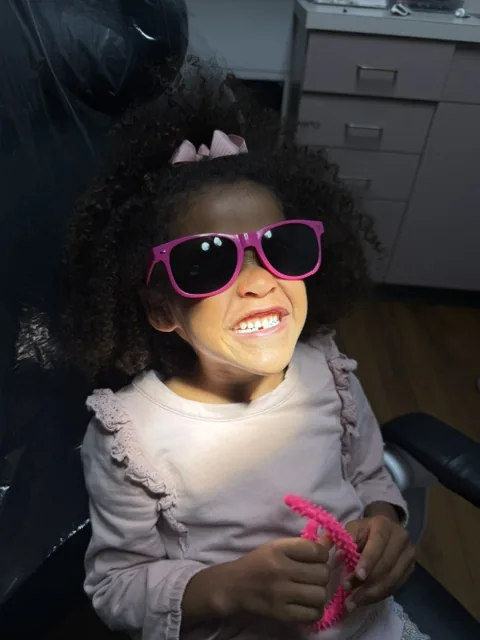 Young patient wearing protective sunglasses in the dental chair